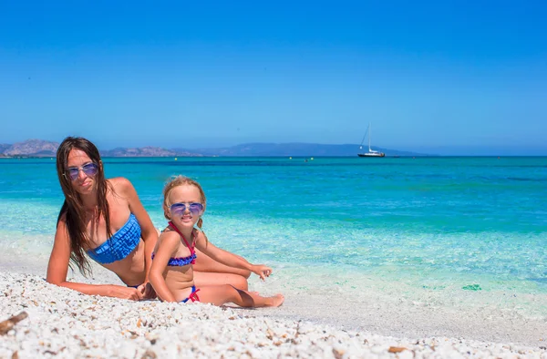 Szczęśliwa mama i jej urocza córka trochę podczas letnich wakacji na plaży — Zdjęcie stockowe