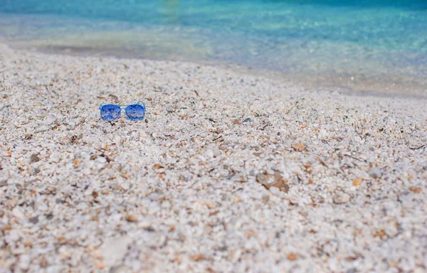 Close up of colorful blue sunglasses on tropical beach — Stock Photo, Image