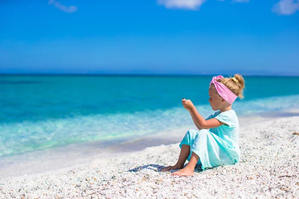 Aranyos kislány fényképet a tenger, a telefon a tropical beach — Stock Fotó