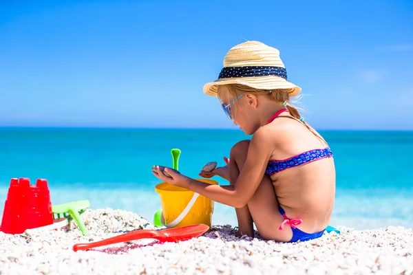 Urocza dziewczynka gra z zabawki na wakacje na plaży — Zdjęcie stockowe