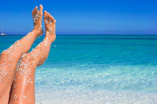 Крупним планом жіночі ноги фон бірюзового моря — стокове фото
