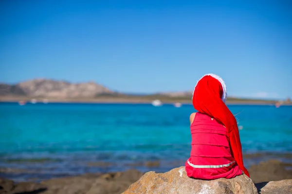 Adorabile bambina in cappello di Natale durante le vacanze al mare — Foto Stock