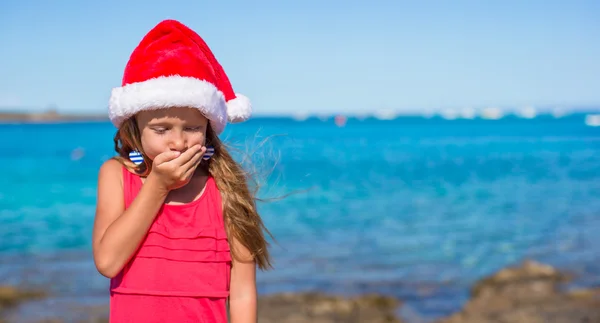 Adorable little girl in santa hat during beach vacation — Stock Photo, Image