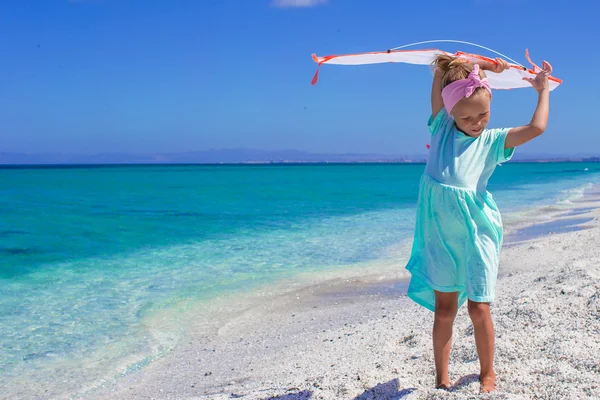 Niña feliz jugando con cometa voladora en la playa tropical —  Fotos de Stock