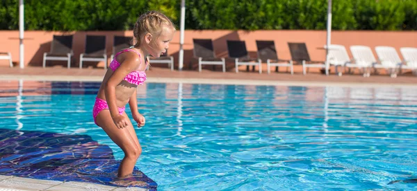 Sevimli mutlu küçük kız havuzda yüzmenin keyfini çıkar. — Stok fotoğraf