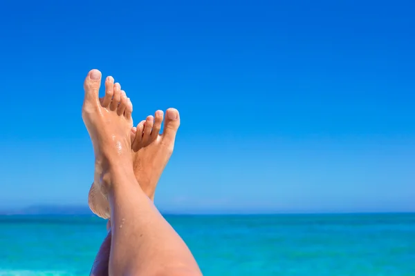 Closeup of female legs background of the turquoise sea — Stock Photo, Image