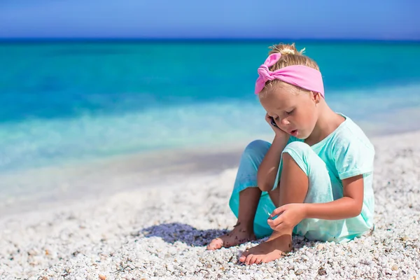 Schattig meisje met mobiele telefoon tijdens strandvakantie — Stockfoto