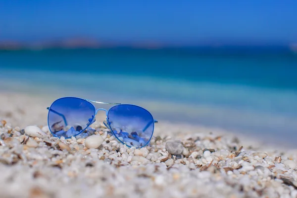 Närbild på färgglada blå solglasögon på tropical beach — Stockfoto
