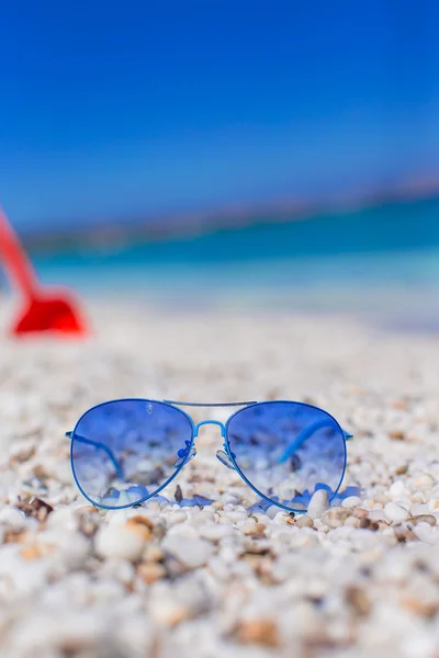 Närbild på färgglada blå solglasögon på tropical beach — Stockfoto