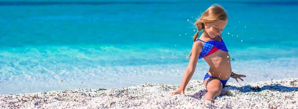 Κοριτσάκι, καθιστώντας το πόδι-split σε τροπική παραλία με λευκή άμμο — Φωτογραφία Αρχείου