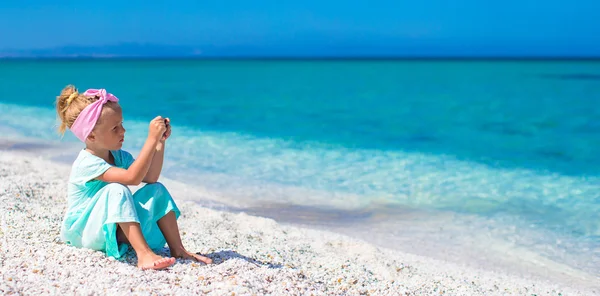 Schattig meisje nemen foto van de zee op telefoon op tropische strand — Stockfoto