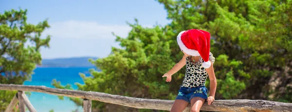 Entzückendes kleines Mädchen mit Weihnachtsmütze im Sommerurlaub am Strand — Stockfoto