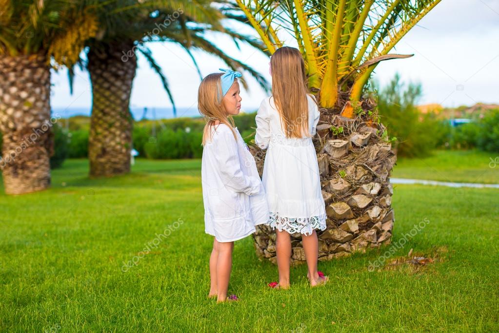 Adorable little girls in exotic resort at sunset