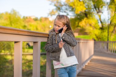 Dışarıda, sıcak bir sonbahar gününde, sevimli küçük bir kız.