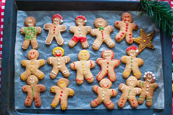 Raw gingerbread men with glaze on a baking sheet — Stock Photo, Image