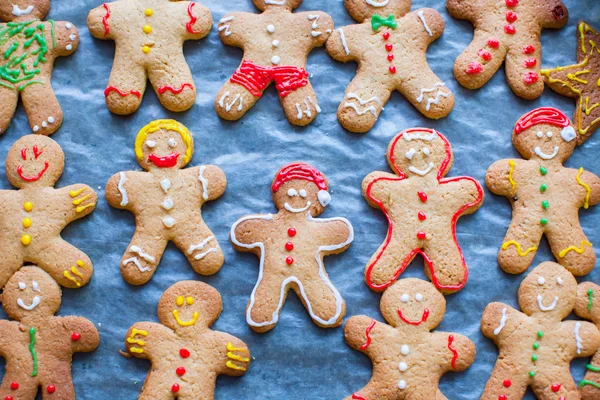 Cute gingerbread men on baking sheet for Christmas — Stock Photo, Image