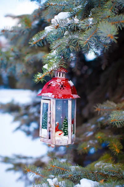 Декоративный рождественский фонарь на еловой ветке в снежный зимний день — стоковое фото