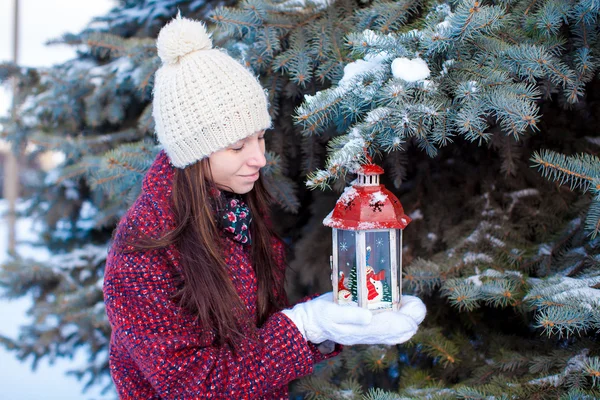 Jong meisje met rode Kerst lantaarn in de sneeuw — Stockfoto