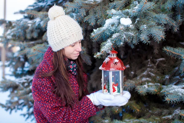 Chica joven con linterna roja de Navidad en la nieve — Foto de Stock