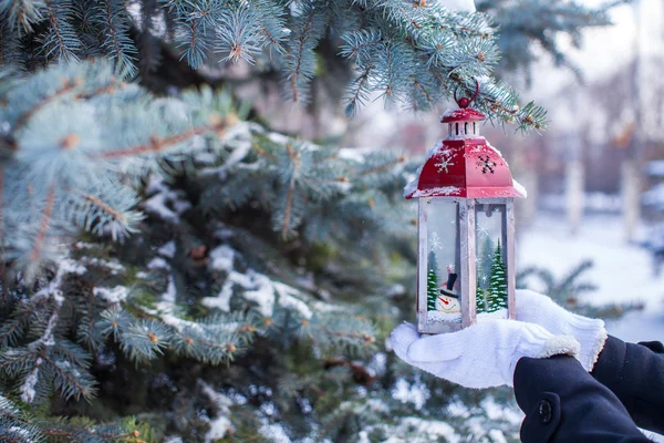 Beautiful red decorative Christmas lantern on warm mittens — Stock Photo, Image