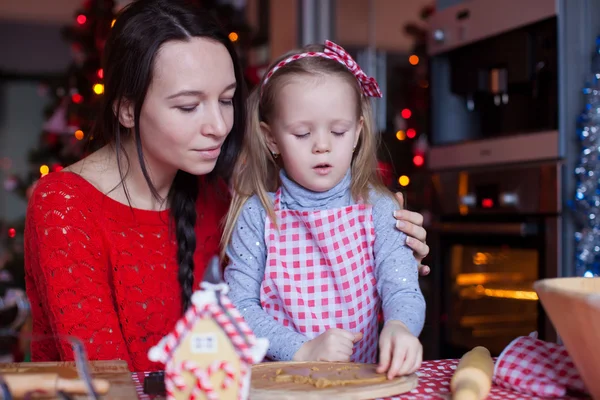 Маленькая очаровательная девочка и мама пекут рождественские пряники — стоковое фото
