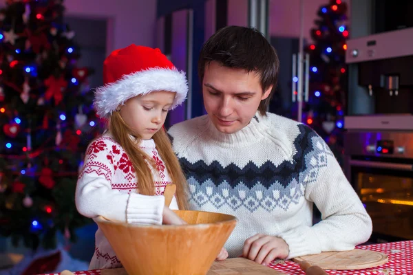 Young dad and little girl in Santa hat bake gingerbread cookies — Stock Photo, Image