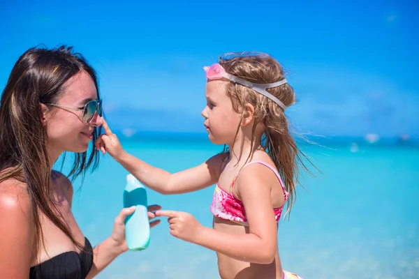 Malá holčička použitím opalovací krém na nose máma — Stock fotografie