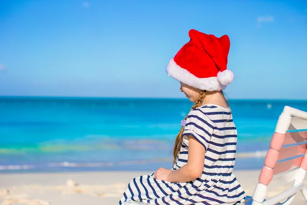 Schattig meisje dragen KERSTMUTS op tropisch strand — Stockfoto