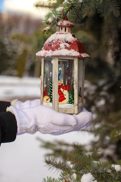 Vackra röda dekorativa jul lykta på varma vantar — Stockfoto