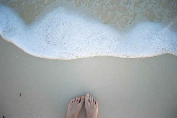 Frauen schöne Beine am weißen Sandstrand — Stockfoto