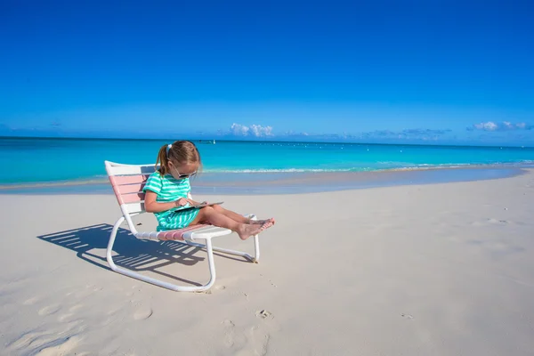 Kleines Mädchen mit Laptop am Strand während der Sommerferien — Stockfoto