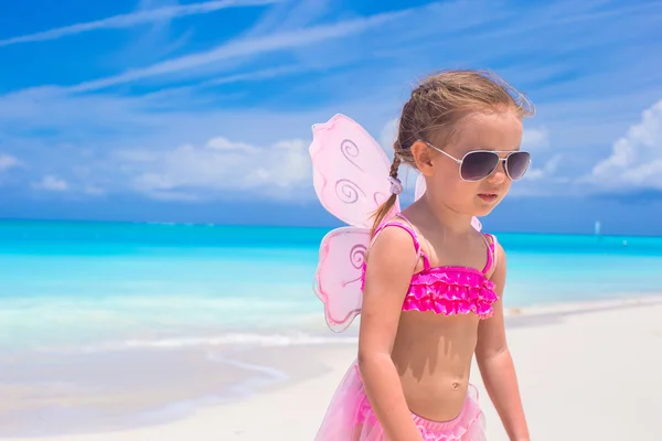 Entzückendes kleines Mädchen mit Flügeln wie ein Schmetterling im Strandurlaub — Stockfoto