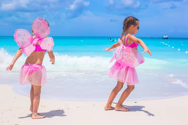 Kleine meisjes in edelstaal met vlinder vleugels veel plezier strand zomervakantie — Stockfoto