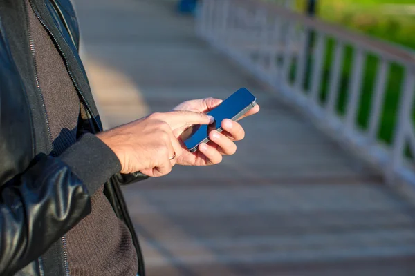 Gros plan mans mains en utilisant le téléphone mobile à l'extérieur — Photo