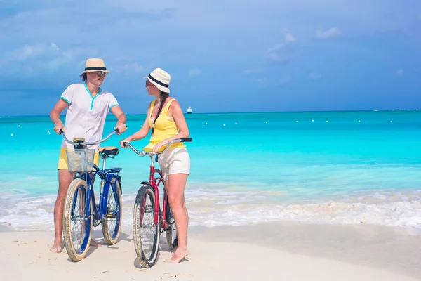 Joven pareja feliz montando bicicletas durante las vacaciones tropicales — Foto de Stock