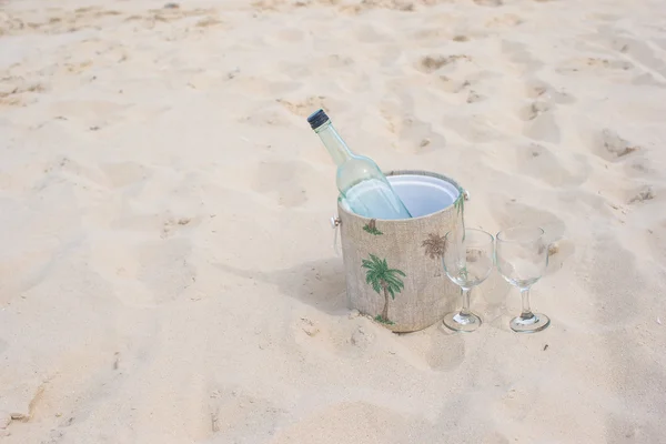 Botella de vino y dos copas en la playa de arena —  Fotos de Stock