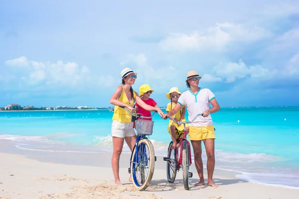 Jovem família feliz andar de bicicleta na praia tropical — Fotografia de Stock