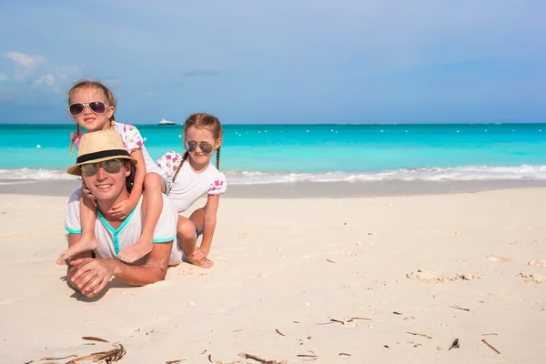Šťastný otec a rozkošné malé dcery na tropické pláži — Stock fotografie