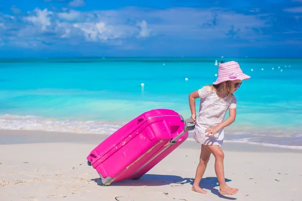 Rozkošná holčička s velkým kufrem na tropické dovolené — Stock fotografie