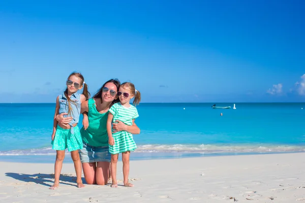 Pequenas meninas bonitos e jovem mãe durante as férias na praia tropical — Fotografia de Stock