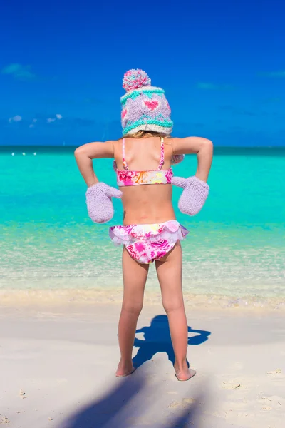Petite adorable fille en bonnet tricoté chaud et mitaines sur la plage — Photo