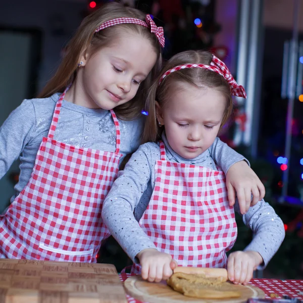 Kleine meisjes in wanten bakken kerstkoekjes peperkoek — Stockfoto