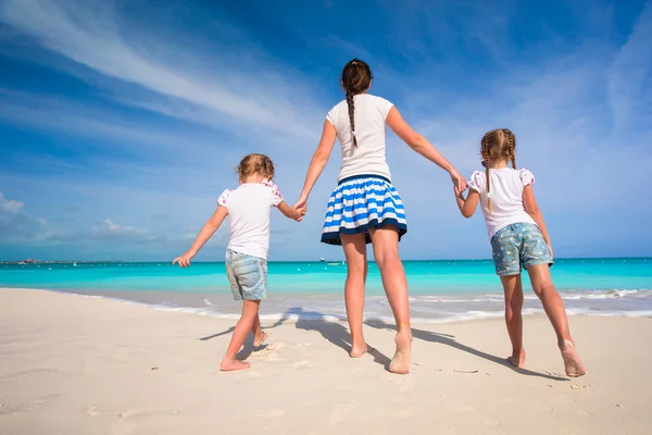 Young happy mother and her adorable daughters having fun at exotic beach on sunny day — Stock Photo, Image