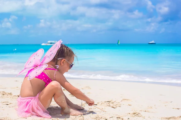 Adorable little girl with wings like butterfly on beach vacation — Stock Photo, Image