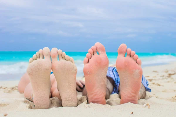 Крупный план мужских и женских ног на белом песке — стоковое фото