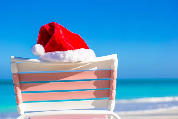 Sombrero rojo de Santa en silla longue en la playa tropical — Foto de Stock