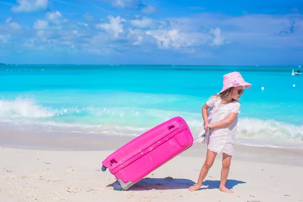 Tropik sahilde büyük bavul ile küçük sevimli kız — Stok fotoğraf