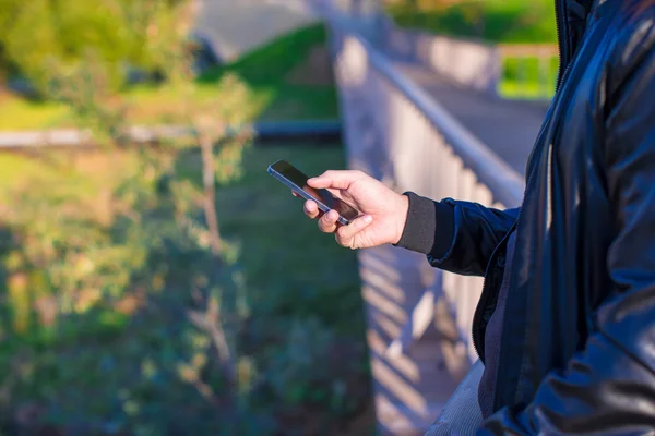 Närbild mans händer med mobiltelefon utomhus — Stockfoto