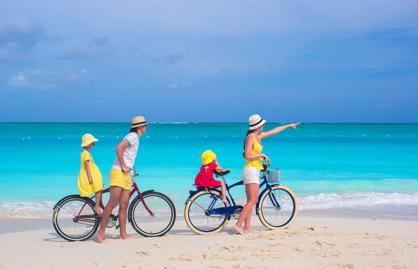 Giovani famiglie in bicicletta sulla spiaggia tropicale — Foto Stock