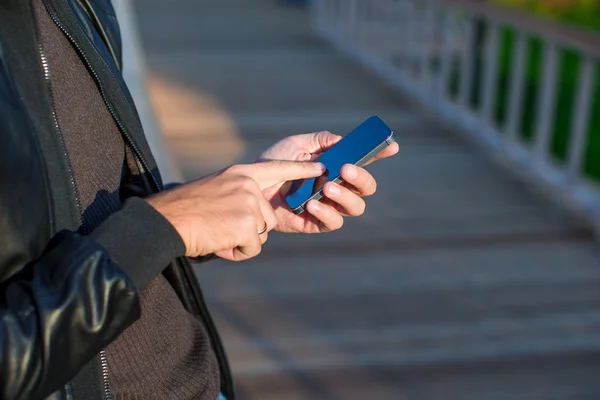 Närbild mans händer med mobiltelefon utomhus — Stockfoto